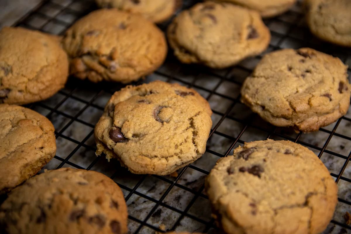 Cookies au chocolat sortis du four sur une grille noire
